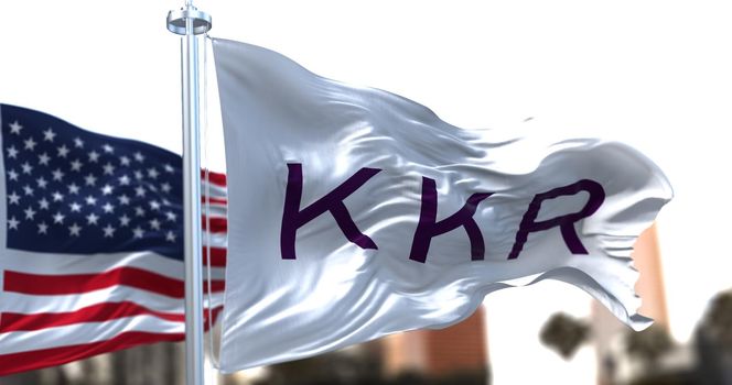 New York, USA, November 2021: The flag With KKR logo waving in the wind with the American national flag in the background