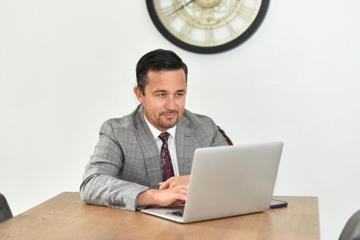 Mature man works at the laptop
