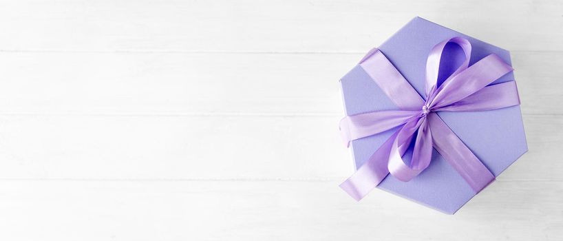 Beautiful gift box with lavander ribbon for celebration isolated on white background with copy space. Romantic present package from above view