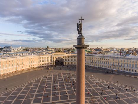 Aerial view of Palace Square and Alexander Column at sunset, a dome of Kazanskiy Cathedral on background, the Winter Palace, walking a little people. High quality photo