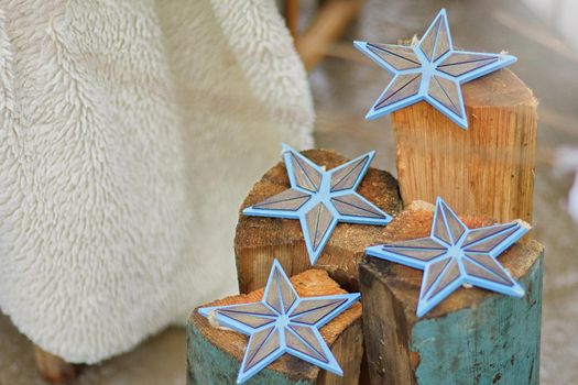 Christmas decor outside: wooden flat blue star figurines, on wooden pillars