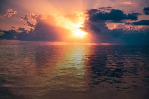 Natural landscape with dramatic sunset on the background of the calm blue sea