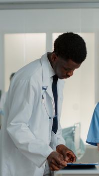 Woman working as nurse using laptop to help doctor with healthcare treatment. Medical assistant working on computer and giving support to physician, helping with medical practice.