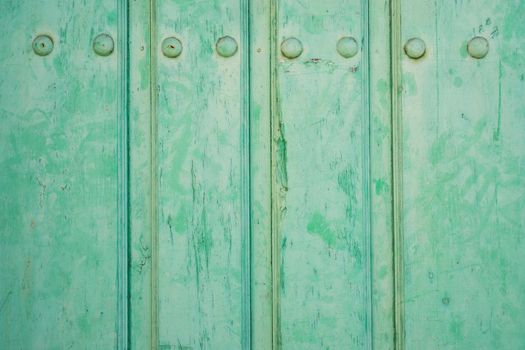 Closeup of vintage run-down wooden door (green painted)