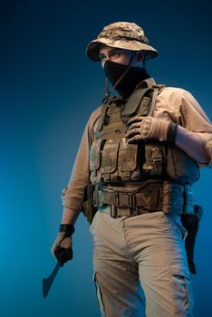 an army soldier in military clothes with a machete in his hand