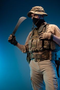 an army soldier in military clothes with a machete in his hand