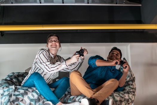 Work hard play hard. Workers Playing computer games man against a woman during break-in relaxation area at creative startup Office. High-quality photo