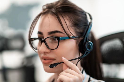 Business and technology concept - helpline female operator with headphones in a call center.Businesswoman with headsets working in a call center. High-quality photo