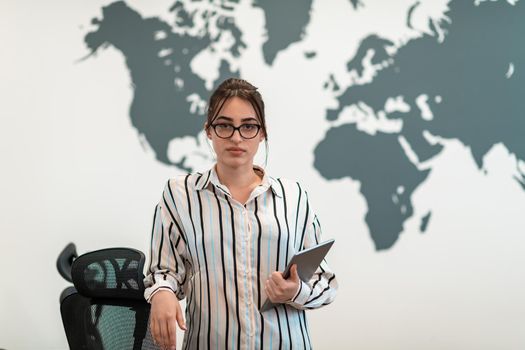 Portrait of businesswoman in casual clothes holding tablet computer at modern startup open plan office interior. Selective focus. High-quality photo