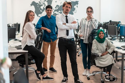 Portrait of young excited multiethnics business team of software developers standing and looking at the camera at modern startup office. High-quality photo