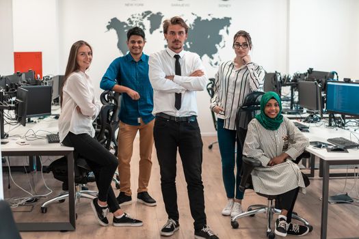 Portrait of young excited multiethnics business team of software developers standing and looking at the camera at modern startup office. High-quality photo