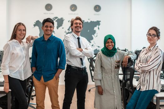 Portrait of young excited multiethnics business team of software developers standing and looking at the camera at modern startup office. High-quality photo