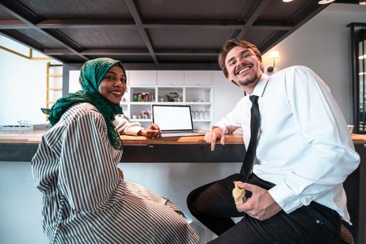 International multicultural business team. A young businessman and businesswoman sit in a modern relaxation space and talk about a new business. High-quality photo