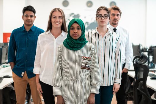 Portrait of young excited multiethnics business team of software developers standing and looking at the camera at modern startup office. High-quality photo