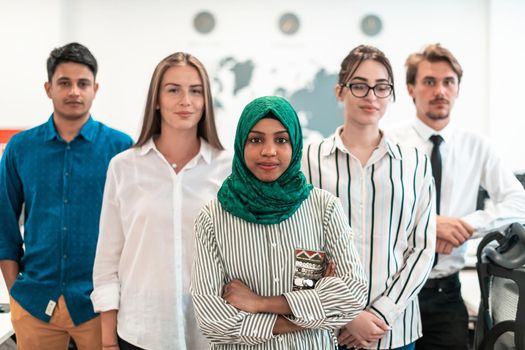 Portrait of young excited multiethnics business team of software developers standing and looking at the camera at modern startup office. High-quality photo