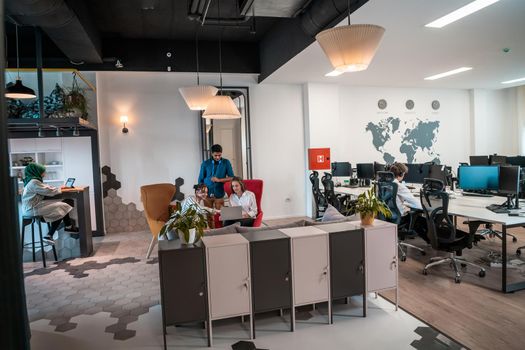 group of casual multiethnic business people taking break from the work doing different things while enjoying free time in relaxation area at modern open plan startup office. High quality photo