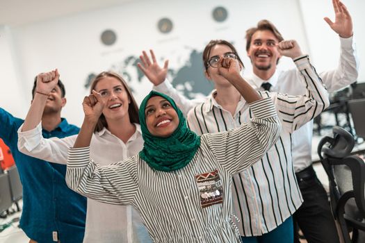 Portrait of young excited multiethnics business team of software developers standing and looking at the camera at modern startup office. High-quality photo