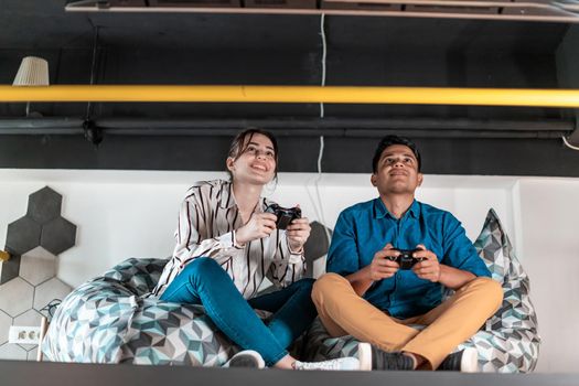 Work hard play hard. Workers Playing computer games man against a woman during break-in relaxation area at creative startup Office. High-quality photo