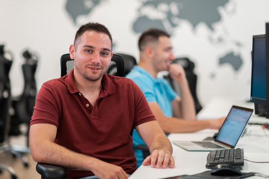 Group of Casual businessmen working on a desktop computer in modern open plan startup office interior. Selective focus. High-quality photo