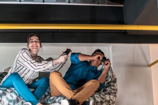 Work hard play hard. Workers Playing computer games man against a woman during break-in relaxation area at creative startup Office. High-quality photo