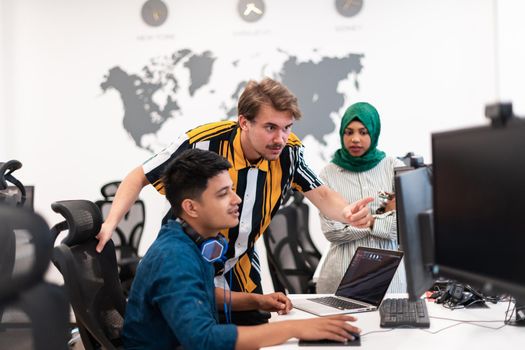 Multiethnic startup business team Arabian woman wearing a hijab on meeting in modern open plan office interior brainstorming, working on laptop and desktop computer. Selective focus. High-quality photo