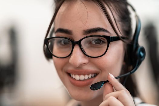 Business and technology concept - helpline female operator with headphones in a call center.Businesswoman with headsets working in a call center. High-quality photo