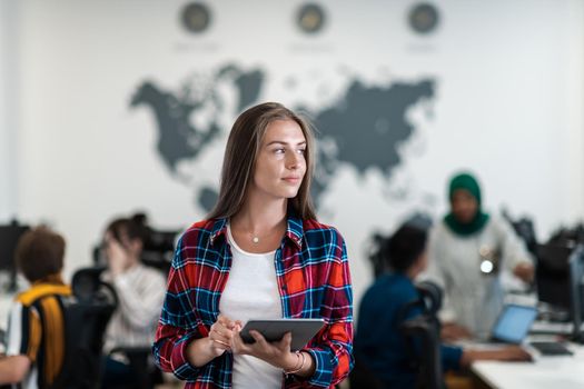 Portrait of businesswoman in casual clothes holding tablet computer at modern startup open plan office interior. Selective focus. High-quality photo