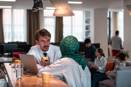 International multicultural business team. A young businessman and businesswoman sit in a modern relaxation space and talk about a new business. High-quality photo