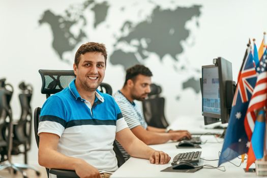 Group of Casual businessmen working on a desktop computer in modern open plan startup office interior. Selective focus. High-quality photo