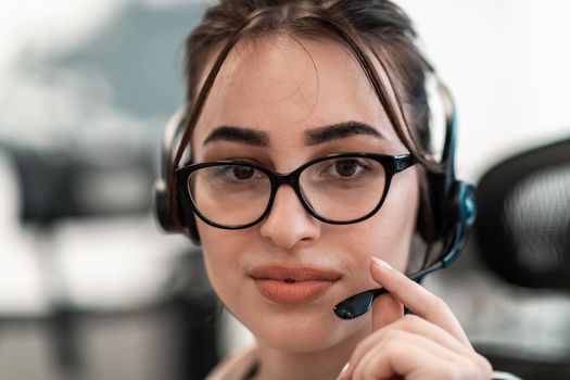 Business and technology concept - helpline female operator with headphones in a call center.Businesswoman with headsets working in a call center. High-quality photo