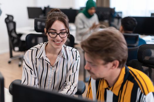 Business couple working together on a project using tablet and desktop computer at modern open plan startup office. Selective focus. High-quality photo