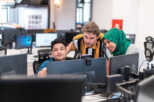 Multiethnic startup business team Arabian woman wearing a hijab on meeting in modern open plan office interior brainstorming, working on laptop and desktop computer. Selective focus. High-quality photo