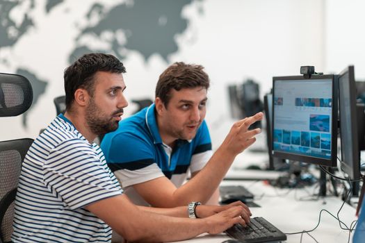 Group of Casual businessmen working on a desktop computer in modern open plan startup office interior. Selective focus. High-quality photo