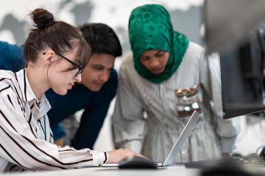 Multiethnic startup business team Arabian woman wearing a hijab on meeting in modern open plan office interior brainstorming, working on laptop and desktop computer. Selective focus. High-quality photo