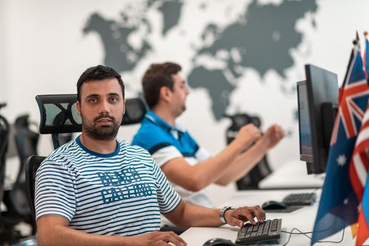 Group of Casual businessmen working on a desktop computer in modern open plan startup office interior. Selective focus. High-quality photo