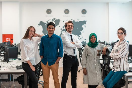 Portrait of young excited multiethnics business team of software developers standing and looking at the camera at modern startup office. High-quality photo