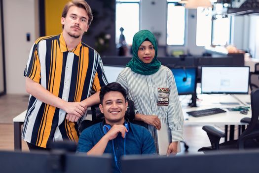 Multiethnic startup business team Arabian woman wearing a hijab on meeting in modern open plan office interior brainstorming, working on laptop and desktop computer. Selective focus. High-quality photo