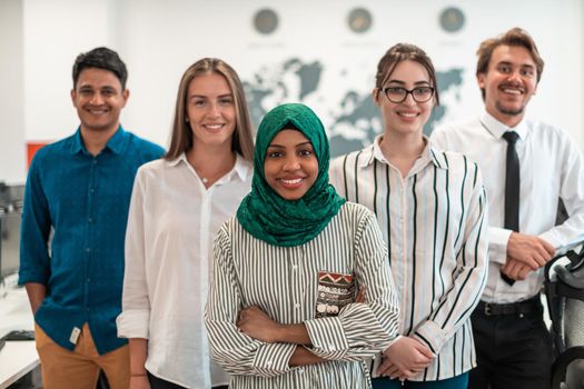 Portrait of young excited multiethnics business team of software developers standing and looking at the camera at modern startup office. High-quality photo