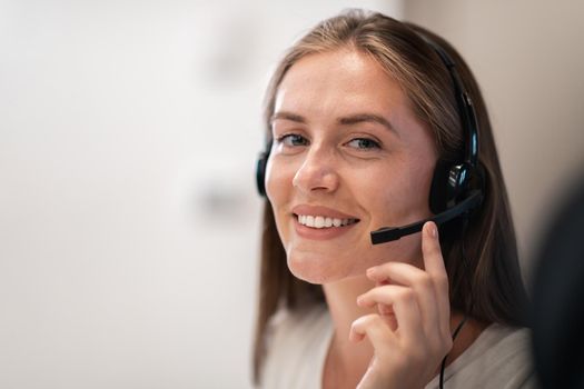 Helpline female operator with headphones in a call center.Business woman with headsets working in a call center. Selective focus. High-quality photo