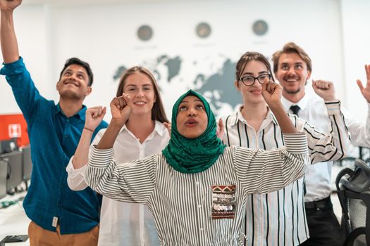 Portrait of young excited multiethnics business team of software developers standing and looking at the camera at modern startup office. High-quality photo