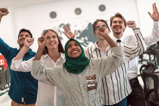 Portrait of young excited multiethnics business team of software developers standing and looking at the camera at modern startup office. High-quality photo