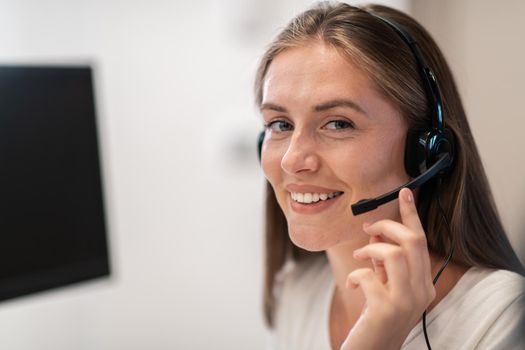 Helpline female operator with headphones in a call center.Business woman with headsets working in a call center. Selective focus. High-quality photo