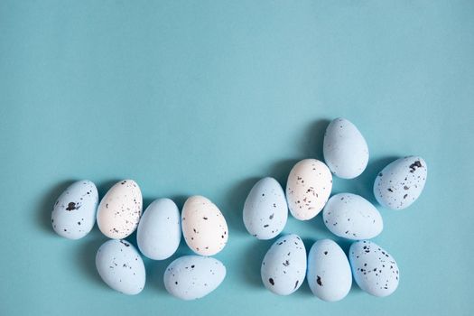 Easter background. Blue and white painted quail eggs on a blue background. Happy Easter holiday.