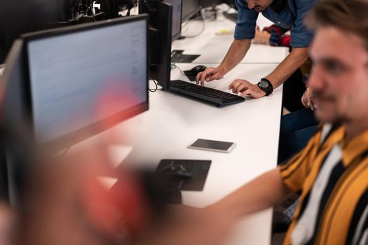 Group of Casual businessmen working on a desktop computer in modern open plan startup office interior. Selective focus. High-quality photo