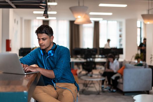 Casual businessman with headphones around his using laptop for an online meeting. Selective focus. High-quality photo