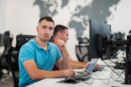 Group of Casual businessmen working on a desktop computer in modern open plan startup office interior. Selective focus. High-quality photo