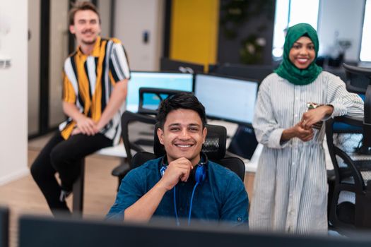 Multiethnic startup business team woman wearing a hijab on meeting in modern open plan office interior brainstorming, working on laptop and desktop computer. Selective focus. High-quality photo