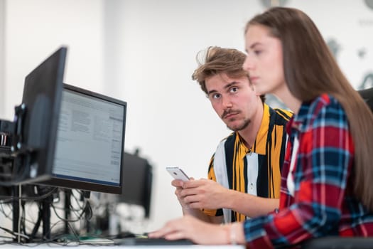 Business couple working together on a project using tablet and desktop computer at modern open plan startup office. Selective focus. High-quality photo