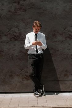 Startup business portrait of casual businessman with a blue shirt and backpack in front of a red wall. High-quality photo