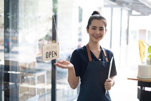Portrait of asian woman barista cafe owner smile while cafe open. SME entrepreneur seller business concept
